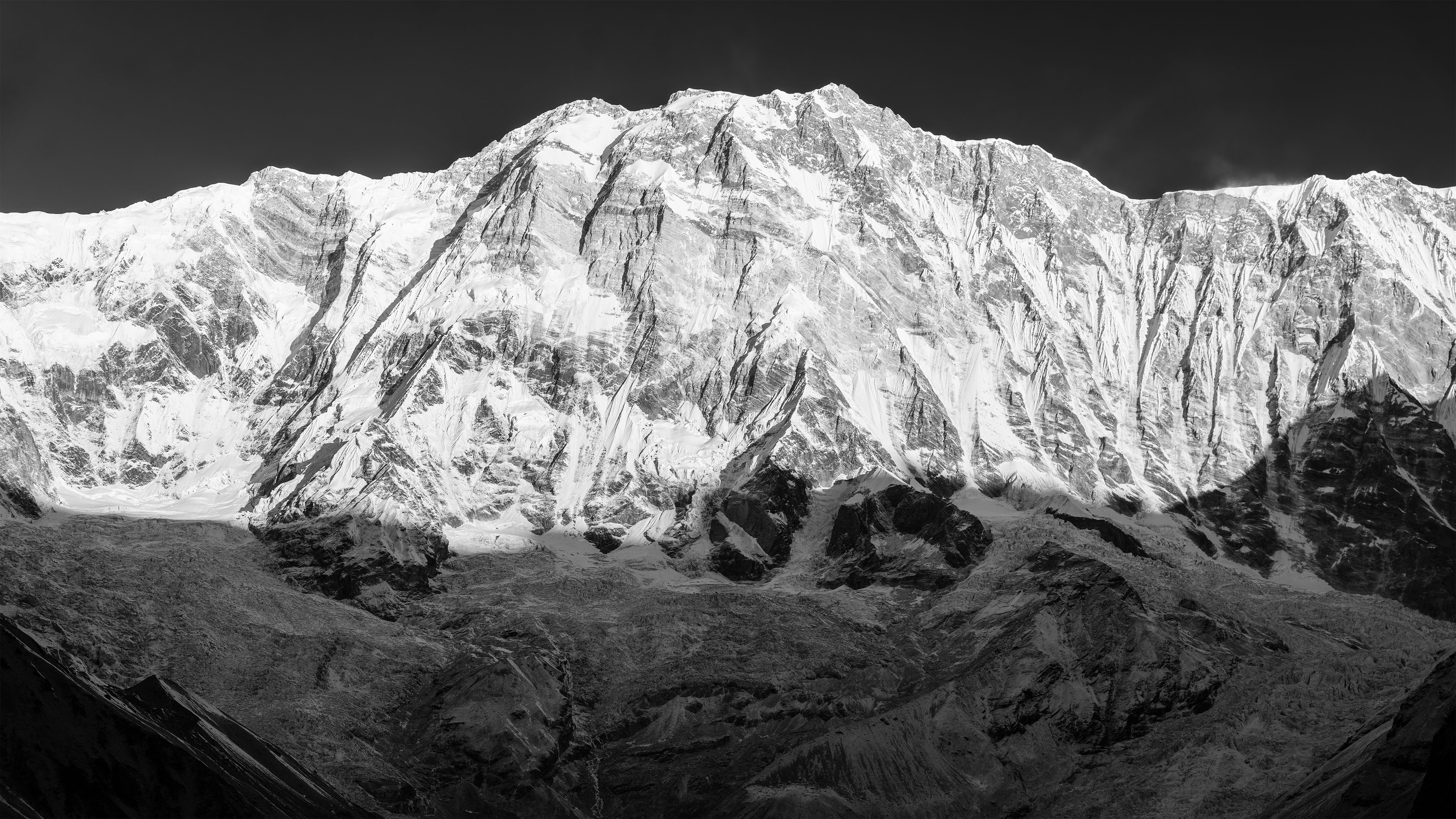 A black and white image of Annapurna I, the tenth highest mountain in the world taken from Annapurna Base Camp in the winter. 