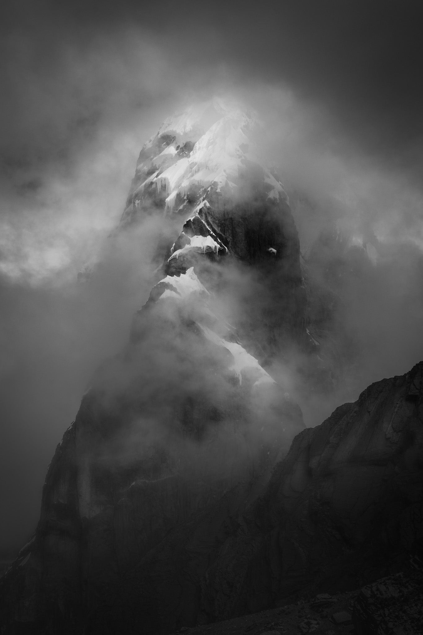 Black and white photograph of Jirishanca peak in Peru shrouded in mist